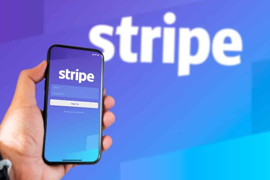 hand holding a phone with Stripe's application login page on the screen .