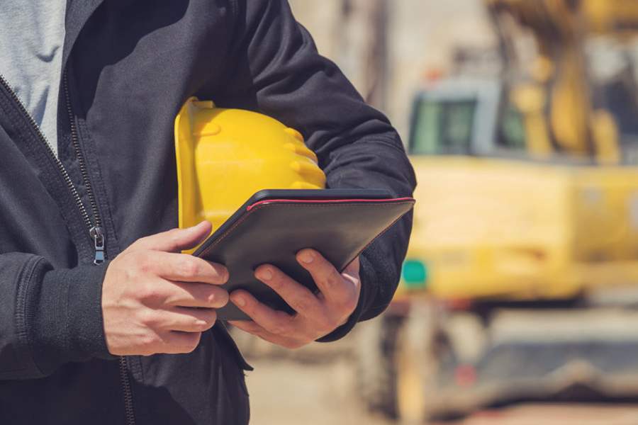 A construction worker using a construction CRM on his iPad.