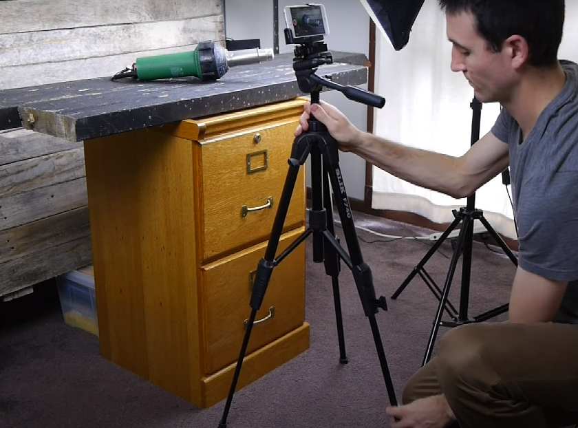 Showing a man setting up camera.