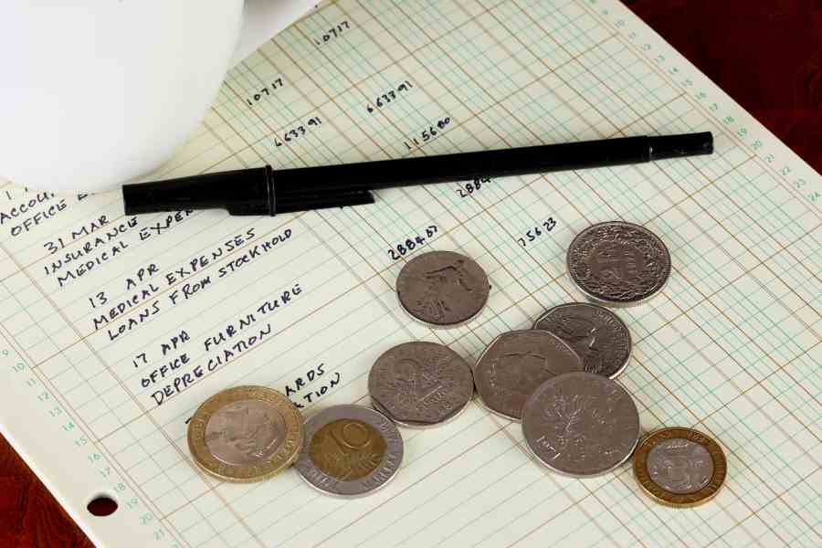 General ledger sheet showing journal entries with coins from various countries.
