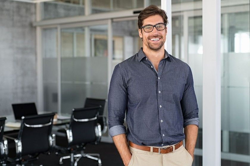 A man smiling at the camera inside the meeting room.