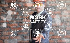 Man in helmet offers work safety icon on virtual screen.
