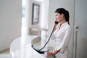 Woman receptionist answering a telephone call.