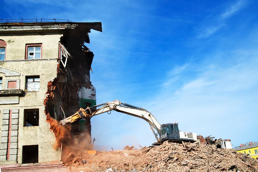 Excavator demolishing an apartment.