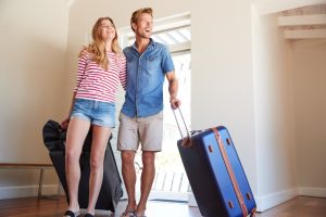 Couple Arriving At Summer Vacation Rental.