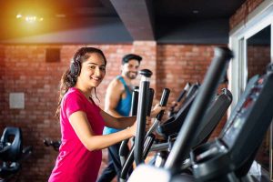 Man and woman doing cardio exercise in a fitness gym.