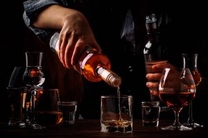 Bartender pouring liquor in glasses.