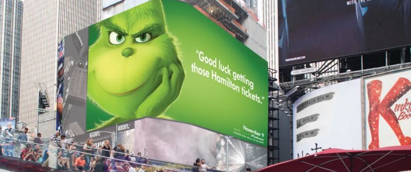 A billboard advertising the movie "The Grinch". in New York City poking fun at the musical "Hamilton."