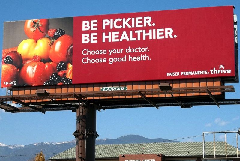 Lamar Billboard ad design that says " Be pickier. Be Healthier" on a red background with fruits on the side.