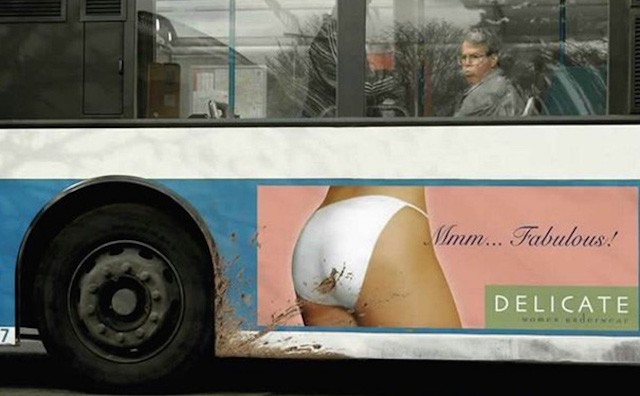 Delicate billboard ad is placed at the wheel-side of the bus and is covered with dirt.