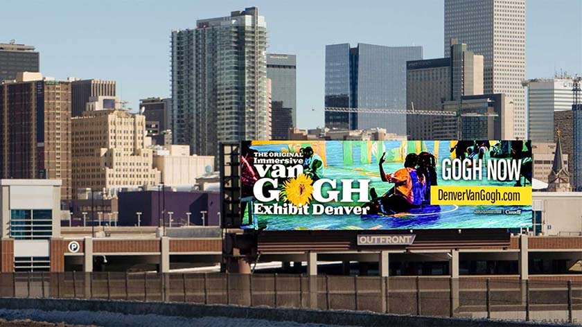 Digital billboard on the side of a road advertising an art exhibit.