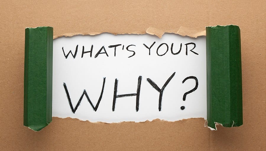 Torn cardboard with text inside that says, "What's your why?"