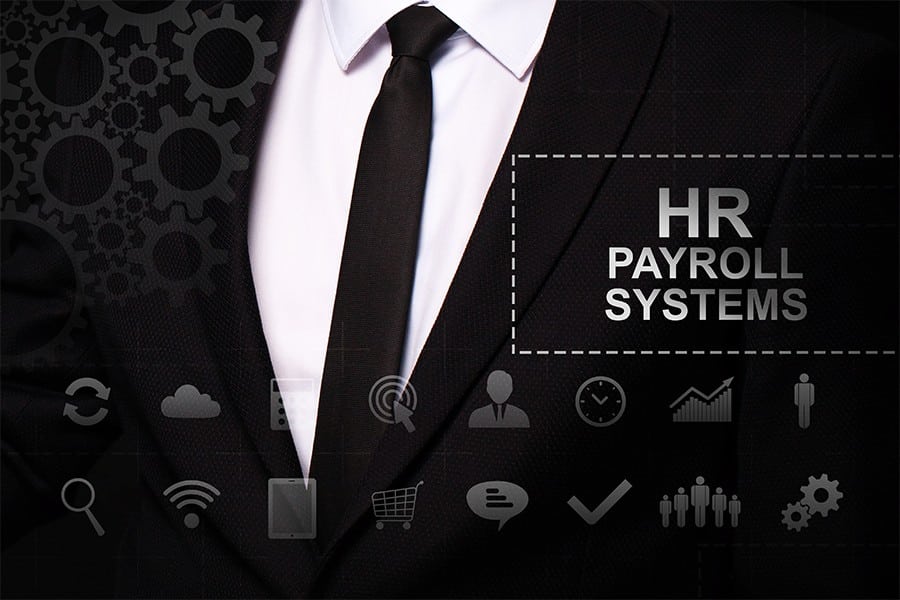 Businessman in the suit close. Text "HR Payroll Systems" on the virtual screen badge, on the chest.