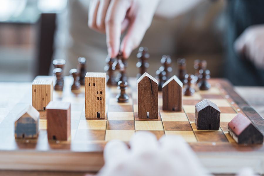 Chess game with wooden house models as chess pieces