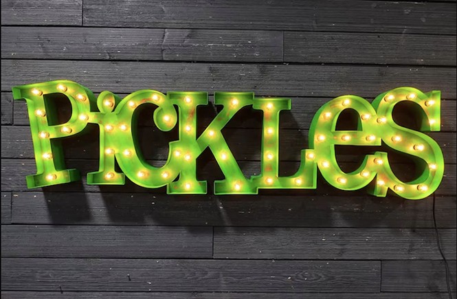 A green indoor marquee sign showing the business's name