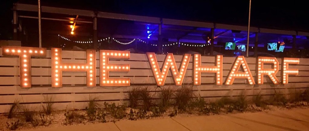 A marquee sign of the business's name mounted on a wall