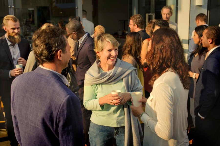 A woman happily conversing with other attendees of a networking event.
