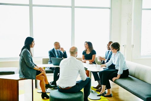 Group of business professionals sitting around a table conversing