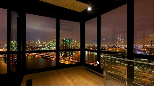 City lights view from corner apartment unit with floor to ceiling windows