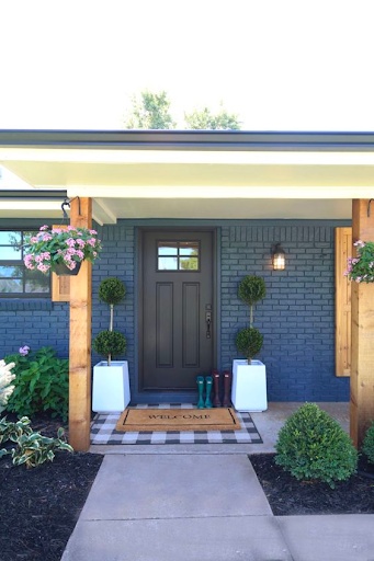 Front porch with two large white planters framing the front door