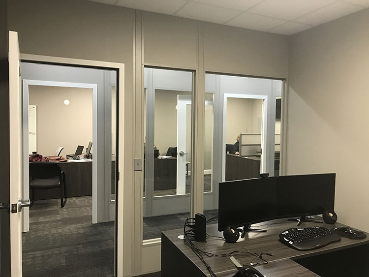 закритий офісний простір з індивідуальними робочими станціями в приватних кімнатах зі скляними дверима, що розділяють їх.