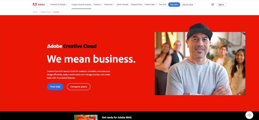 Adobe Creative Cloud homepage in deep red featuring a photo of a casually dressed middle-aged Asian man in the foreground. The headline reads, "We mean business."
