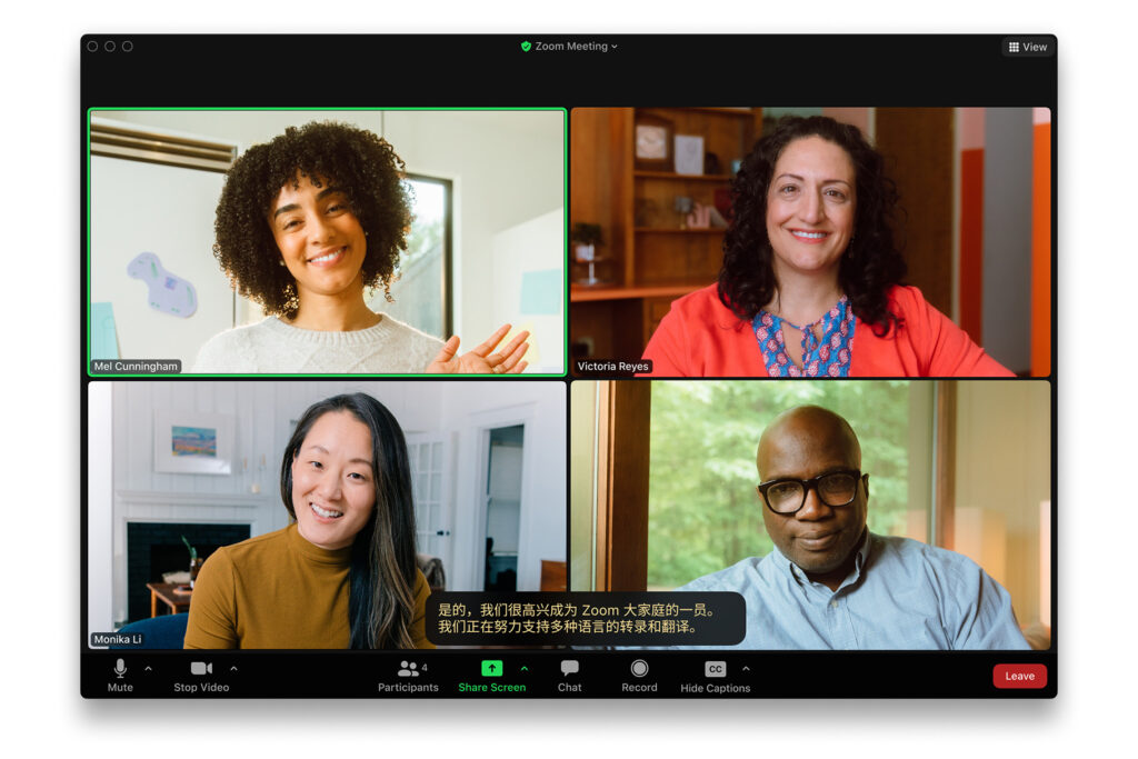 A live Zoom meeting showing four participants and a live caption written in Chinese