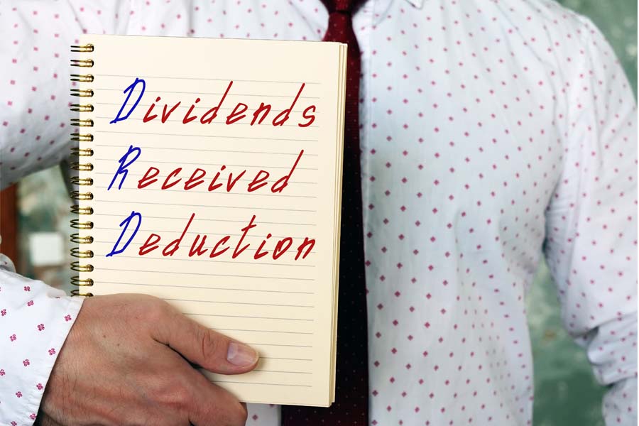 Man Holding a Notebook with Dividends Received Deduction Text