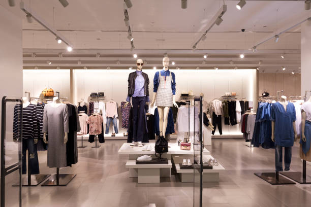 Mannequin and table display in the entry of a modern clothing store.