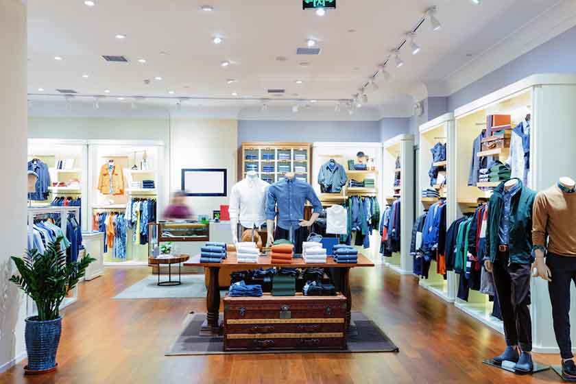 Menswear store with with table display, wall racks, and mannequins.