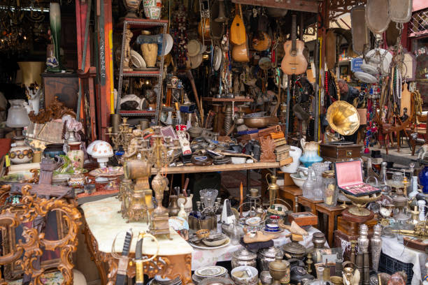 Messy antique store display of old plates, furniture, and other small goods.