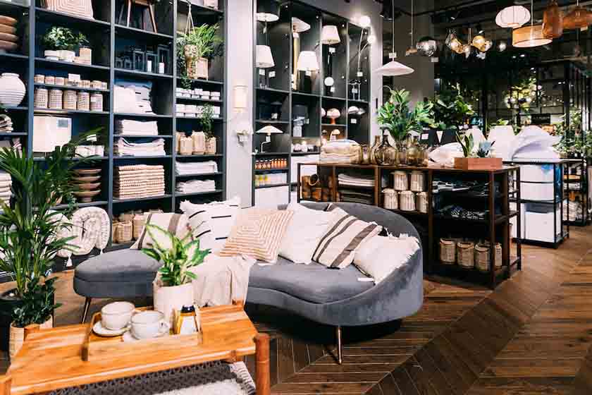 Modern home goods store with lots of furniture and plants of display.
