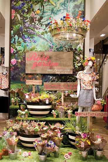 Spring time display in a retail store with lots of flowers and a garden theme.