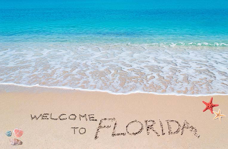 Image of "Welcome to Florida" drawn on sandy beach.