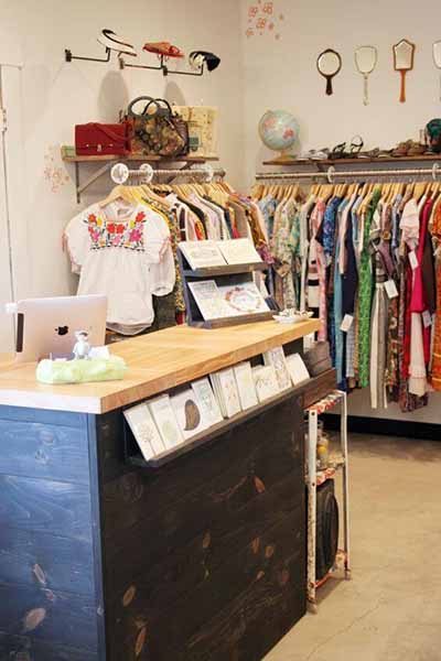 Women's clothing store checkout counter and greeting card display.