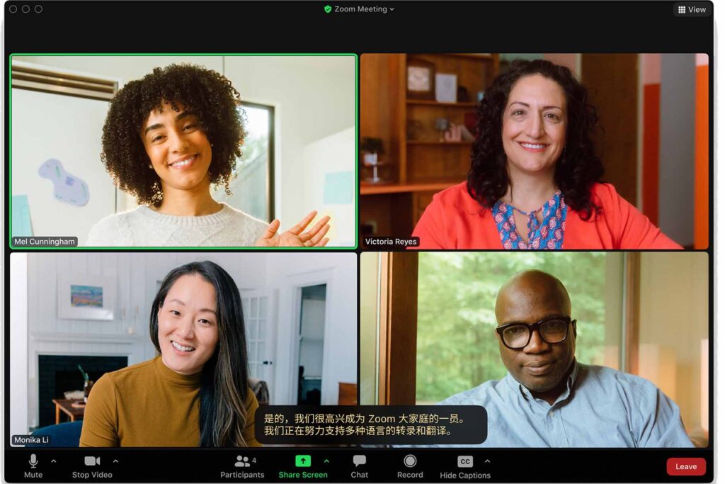 A live Zoom meeting showing the video thumbnails of four participants and a translated caption in the bottom center of the interface