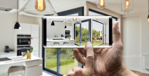 A hand holding a mobile phone that has a image of a kitchen and outdoor space