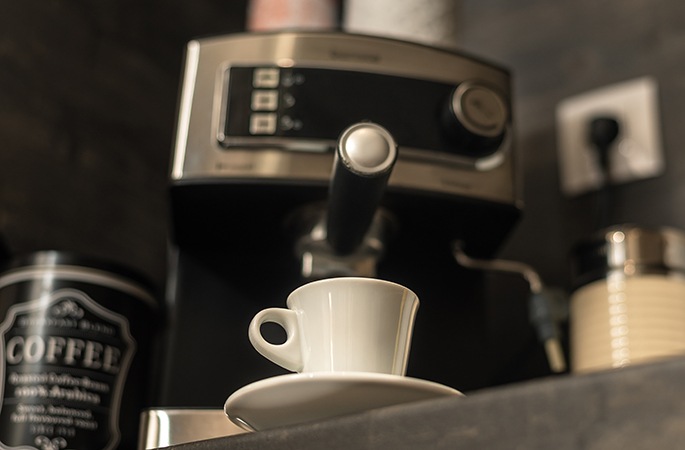 A coffee mug with a coffee machine on the background