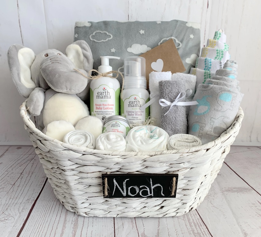 A gift basket full of baby goods with a hand-written name card on the front that reads 'Noah'.