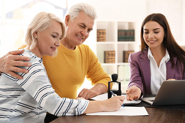 A notary witnessing a couple signing documents.