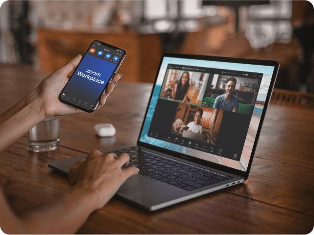 A Zoom user attending a meeting on their laptop and mobile phone.