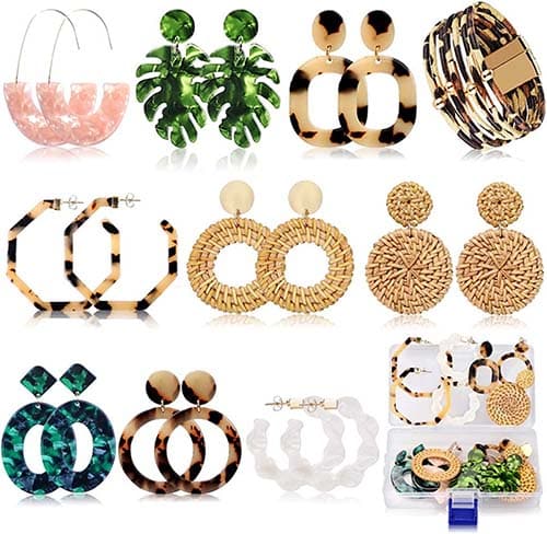 Ten large fashion earrings and case on white background. 