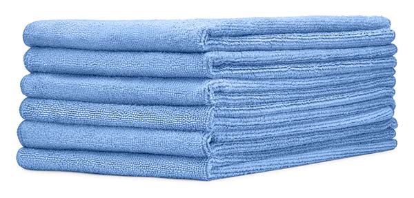 Six blue microfiber clothes stacked on white background.