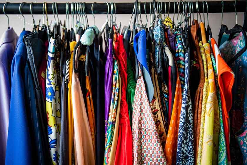 Close-up of clothing rack full of colorful hanging blouses.