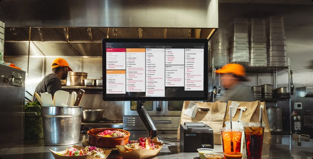 A Square KDS displays multiple customer orders in a busy kitchen.