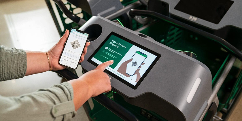 A customer tapping to pay with a smartphone on a payments enabled shopping cart.