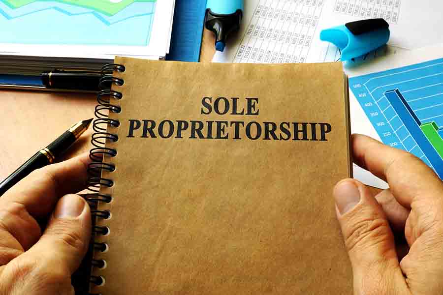 A person holding a notebook with a sole proprietorship written.