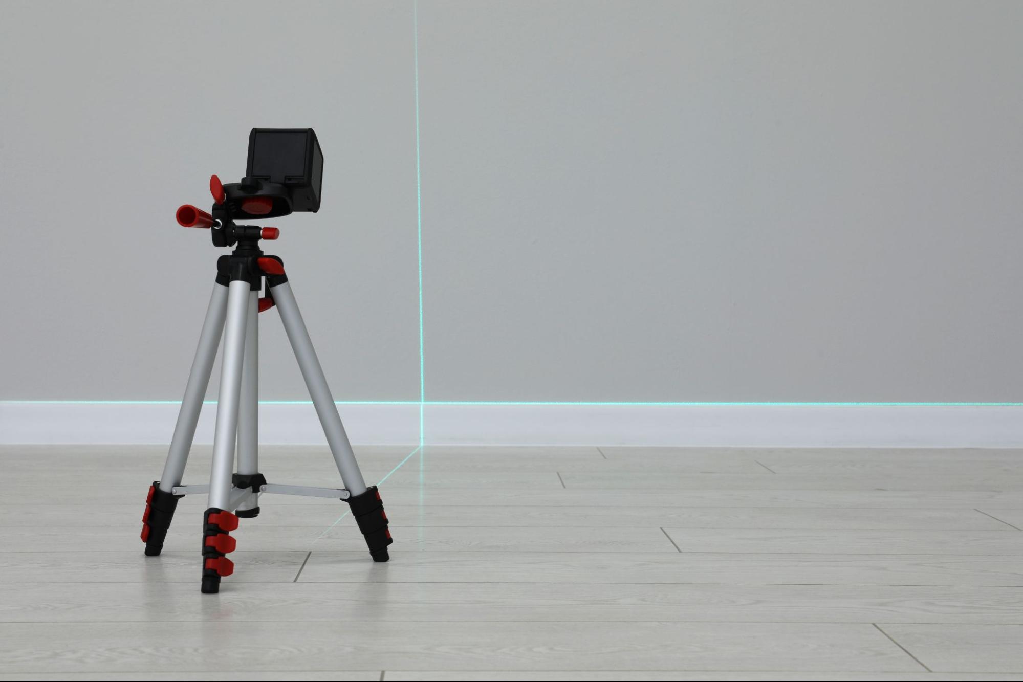 Image of a tripod with level lines against the wall and floor