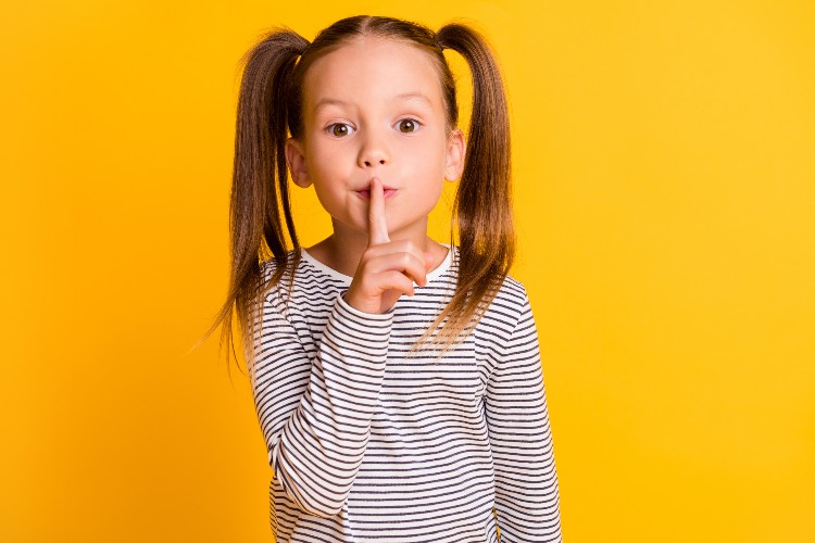 A girl gesturing to keep quiet