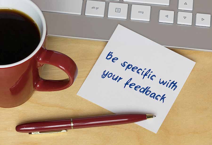 Showing a sticky note saying "Be specific with your feedback".